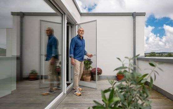 Mann öffnet eine Neher Fliegengitter Drehtür