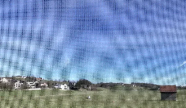 Fast unsichtbares Transpatec Mückengitter mit klarer Sicht auf Landschaft und Himmel